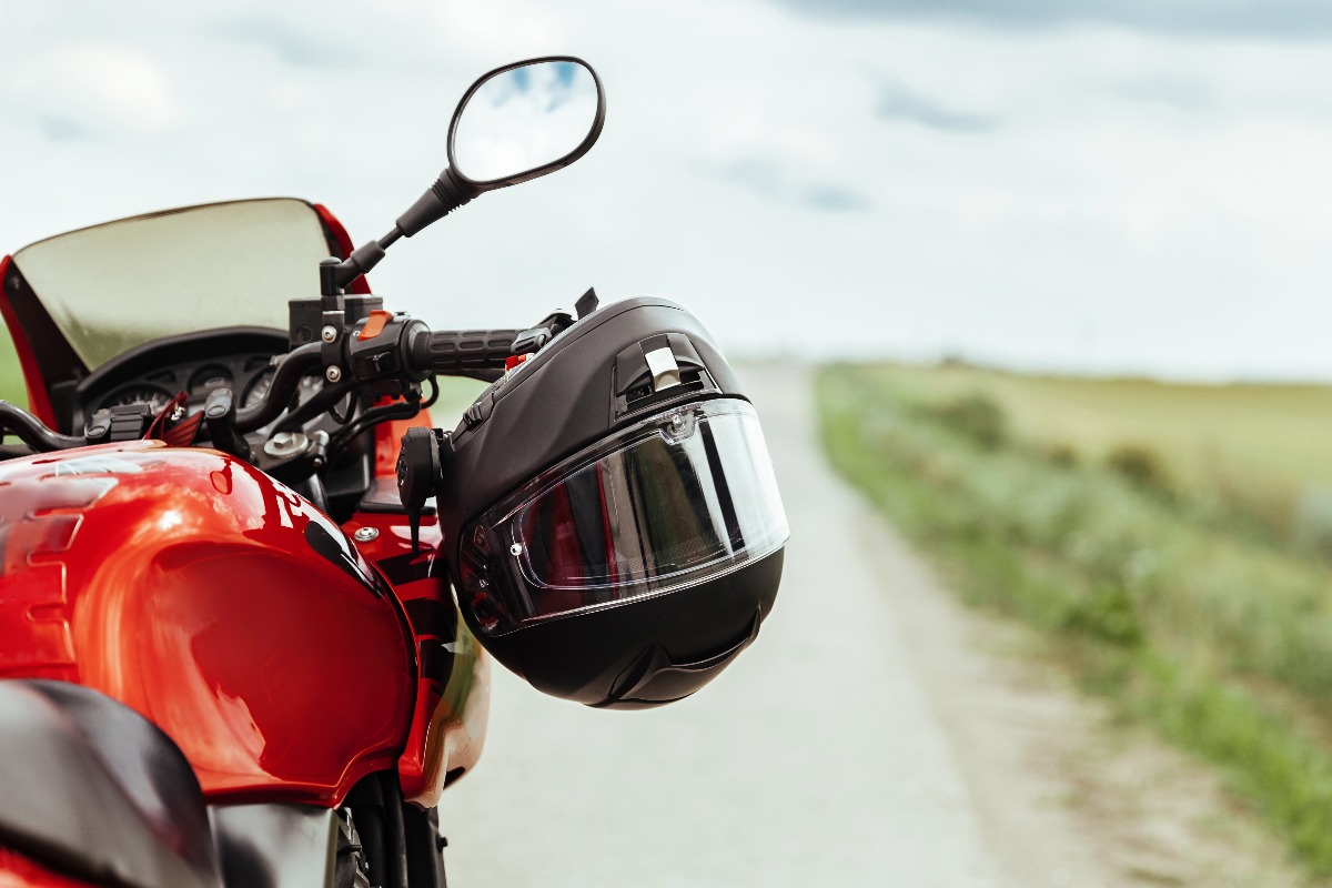 Black motorcycle helmet hanging on the handlebars of the motorcycle jpg